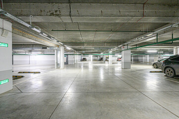 Underground parking. Concrete ceiling and floor with cars parked between pillars