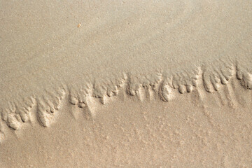 Beautiful ornamental sand patterns made by flowing water on the beach of Baltic Sea. Sunny summer day in Latvia.