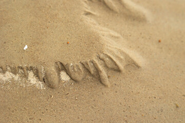 Beautiful ornamental sand patterns made by flowing water on the beach of Baltic Sea. Sunny summer day in Latvia.