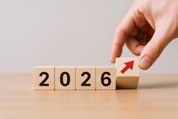 Anticipating Growth: Person Placing Block with Arrow Symbol to Complete the Year 2026