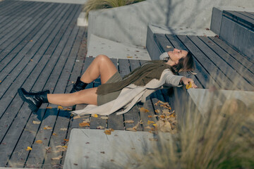 Young caucasian female relaxing on outdoor steps in autumn setting