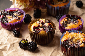 Blackberry muffins on rustic background. Selective focus.