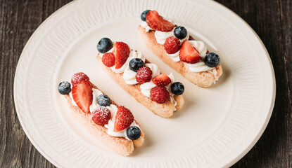 Tiramisu-style dessert with savoiardi, cream cheese and berries. Sweets and desserts.