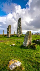 Ancient standing stones in a green grassy field under a blue sky with white clouds