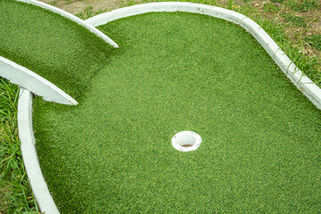 Mini golf lane with artificial turf and hole horizontal