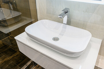 Modern bathroom featuring a sleek white rectangular vessel sink with chrome faucet
