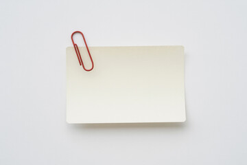 Blank note card attached with a red paperclip on a clean white background