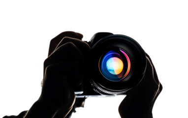 Artistic silhouette of a photographer visible within a camera lens reflection symbolizing vision and creativity isolated on white background PNG