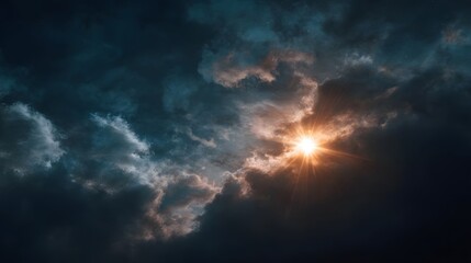 Fototapeta premium A bright sun with intense rays breaks through dark dramatic clouds at dawn creating a powerful natural spectacle