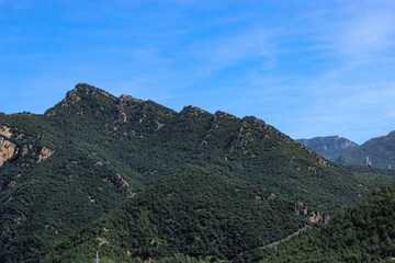 Obraz premium View from La Rodonella towards the densely forested mountain range of El Reu and Cap de Roca-roja that rises majestically above the Embassament de la Baells near La Nou de Berguedà in Catalonia