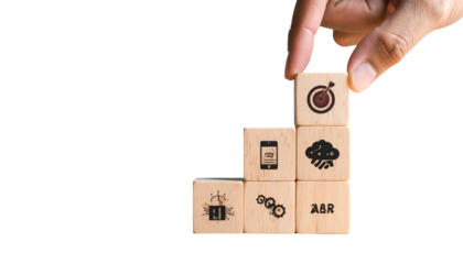 A hand places a cube with a target on a pyramid of cubes depicting business concepts