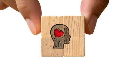 Hand holding wooden puzzle pieces forming a head with heart, set against black