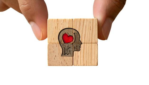 Hand holding wooden puzzle pieces forming a head with heart, set against black