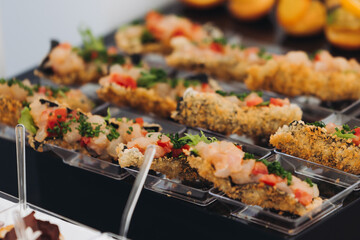 Decorated catering table, banquet with variety of different gourmet exquisite food snacks appetizers on corporate birthday party event or wedding celebration, canape, salad, delicatessen setting