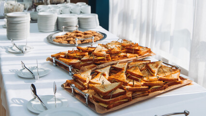 Decorated catering table, banquet with variety of different gourmet exquisite food snacks appetizers on corporate birthday party event or wedding celebration, canape, salad, delicatessen setting