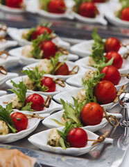 Decorated catering table, banquet with variety of different gourmet exquisite food snacks appetizers on corporate birthday party event or wedding celebration, canape, salad, delicatessen setting