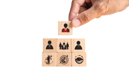 Hand placing person icon block on a pyramid of blocks with various business icons