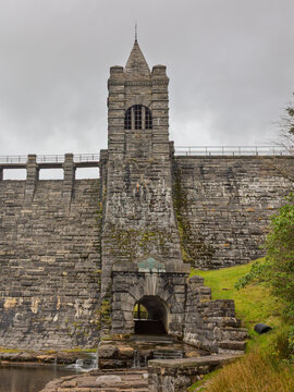 The historic, Grade II listed Upper Neuadd Reservoir stone wall, tunnel outlet and tower with its weathered masonry, on the Taf Fechan river in Bannau Brycheiniog (Brecon Beacons), Powys, Wales