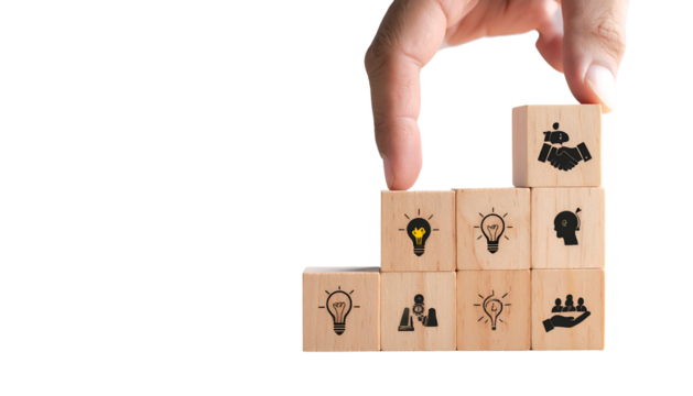 Hand placing a block with handshake icon on a pyramid of blocks with various concept icons - Powered by Adobe