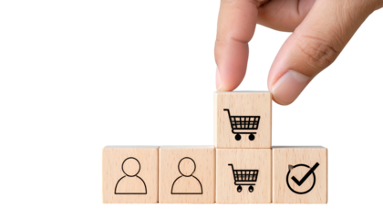 Hand placing shopping cart block on wooden cubes with person, cart, and check symbols