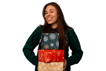 Woman in christmas sweater holding stack of holiday gifts smiling at camera, happy during festive celebration