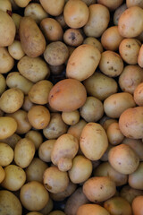 Fresh potatoes with smooth skin and natural earthy spots stacked together in a close-up shot.