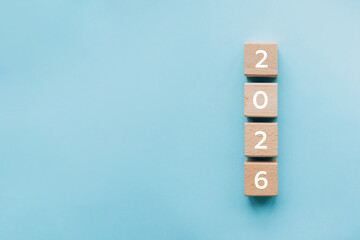 Wooden blocks forming number 2026 on blue background. Simple and modern new year concept representing planning, countdown, or future goals.