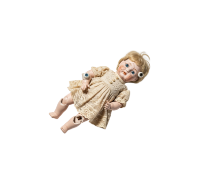 Broken antique porcelain doll with cracked face loose eyes and detached limbs horror concept