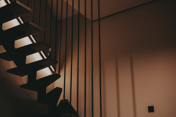 Modern staircase with wooden steps and metal railings in a contemporary home. The architectural design of the staircase creates a visually appealing and functional element within the interior space.