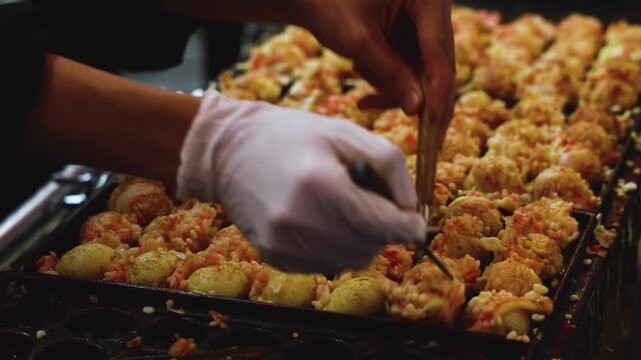 Takoyaki - popular Japanese Street Food, deep-fried dough octopus dumpling balls, variety of different traditional food snack selection in Osaka, Japan, street market with local vendor stalls cooking