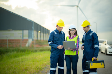 Renewable energy maintenance. Engineers man and woman inspecting construction of wind turbine farm. Wind turbine energy storage system. Workers meeting to check around the area. © sutthinon602