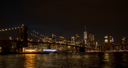Skyline de la ciudad de Nueva York desde Brooklyn una noche oto&ntilde;al. Brooklyn Bridge, Jane's Carousel y Manhattan iluminados desde el c&eacute;sped de Main Street Park. NYC, USA. 2019.