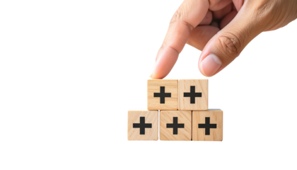 Hand placing wooden blocks with plus signs, forming a pyramid on a black background