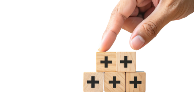 Hand placing wooden blocks with plus signs, forming a pyramid on a black background