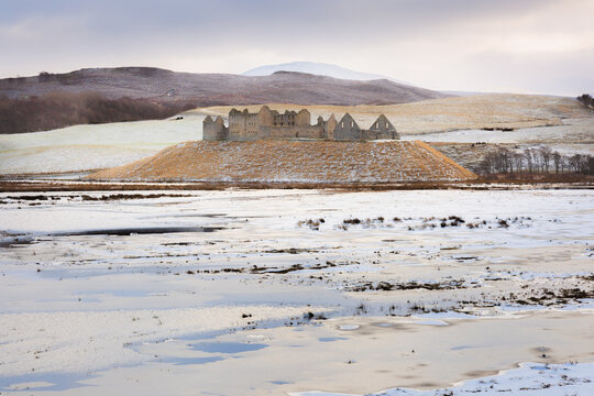 Ruthven Barracks stands on a frosty hill above the frozen Spey Valley in the Cairngorms National Park, Scotland, surrounded by snowy winter scenery and rolling hills.
