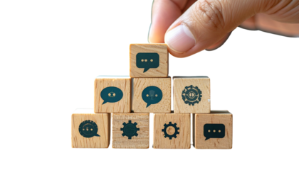 Hand arranging wooden blocks with speech bubbles and gear icons. Black background