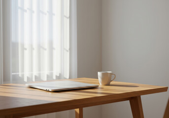 朝の光が差し込む静かな仕事場の木製デスクとラップトップ