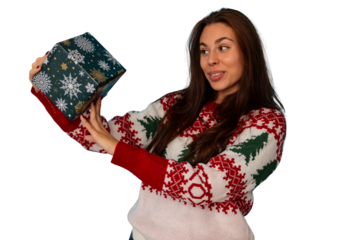 Woman opening holiday present, happy and smiling, dressed in a themed sweater, enjoying the festive winter season celebration