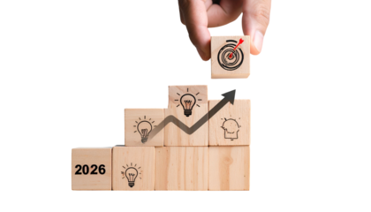 Hand placing target block atop a wooden block staircase with goal-oriented images
