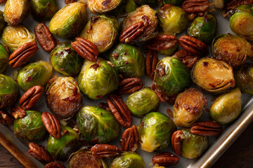 Roasted Brussels sprouts with pecans on a rimmed tray, caramelized edges, overhead graphic composition, editorial clarity