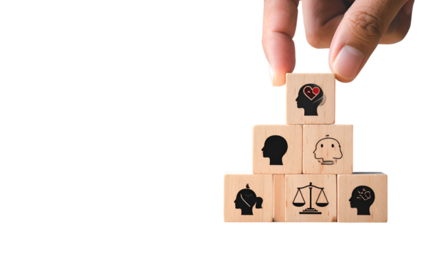 Hand arranging wooden blocks with human-themed icons, building a pyramid on black