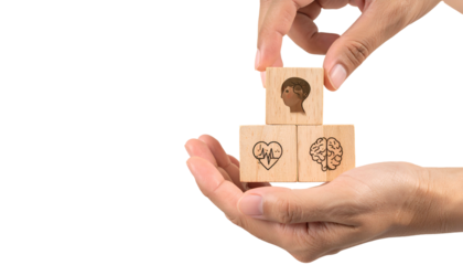 Hands arranging wooden blocks with health icons against black background