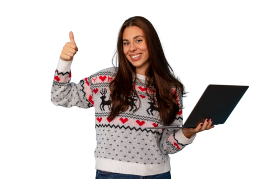 Young woman wearing a christmas sweater and holding a laptop, giving a thumbs up gesture, transparent background