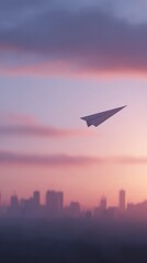 Fototapeta premium Paper airplane flying above city skyline at dawn, ambition and future dream,