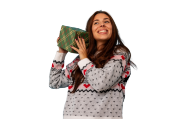 Happy woman holding up and shaking a holiday gift box, wondering about the present inside, transparent background