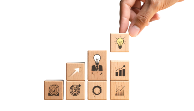 Hand places cube with lightbulb icon atop stacked wooden blocks, black background