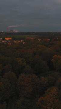 Oddalenie drona odsłania szerszy obszar miasta z parkami i blokami.