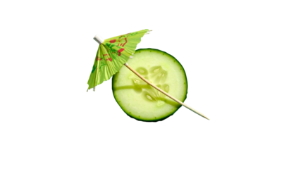Close-up of cucumber slice with cocktail umbrella against a black background