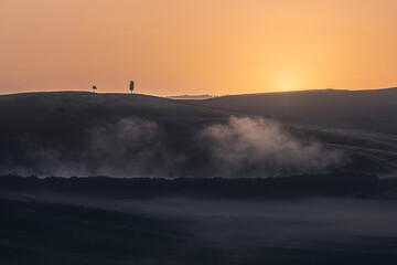 Obraz premium Misty sunrise over rolling hills in Tuscany
