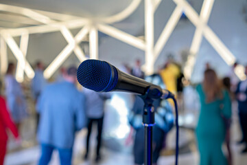 A microphone on a stand in a room with people